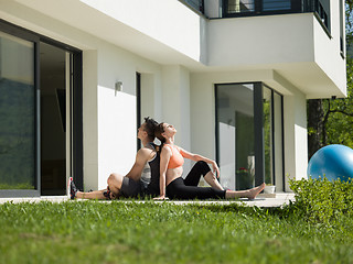 Image showing woman with personal trainer doing morning yoga exercises