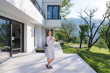 Image showing woman in a bathrobe enjoying morning coffee