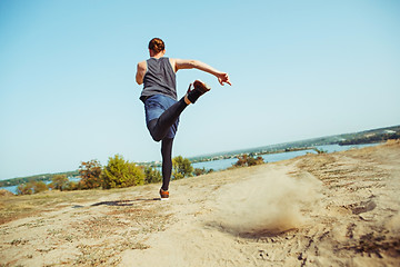 Image showing Running sport. Man runner sprinting outdoor in scenic nature. Fit muscular male athlete training trail running for marathon run.