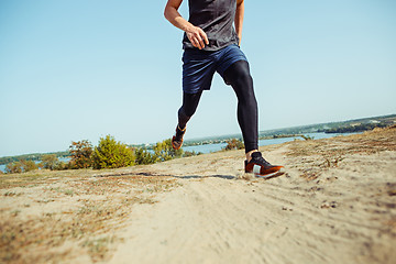 Image showing Running sport. Man runner sprinting outdoor in scenic nature. Fit muscular male athlete training trail running for marathon run.