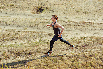 Image showing Running sport. Man runner sprinting outdoor in scenic nature. Fit muscular male athlete training trail running for marathon run.