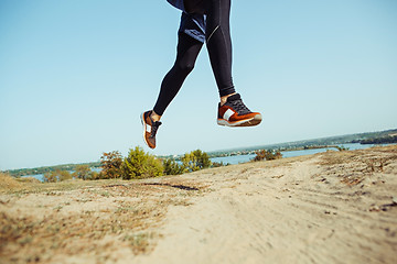 Image showing Running sport. Man runner sprinting outdoor in scenic nature. Fit muscular male athlete training trail running for marathon run.