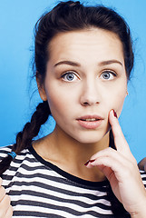 Image showing young pretty woman fooling around on blue background close up smiling