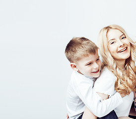 Image showing young modern blond curly mother with cute son together happy smiling family posing cheerful on white background, lifestyle people concept, sister and brother friends 