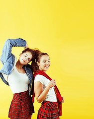 Image showing lifestyle people concept: two pretty young school teenage girls having fun happy smiling on yellow background 