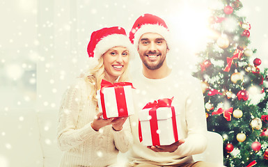 Image showing happy couple at home with christmas gift boxes