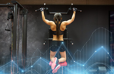 Image showing woman exercising and doing pull-ups in gym