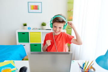 Image showing boy in headphones playing video game on laptop