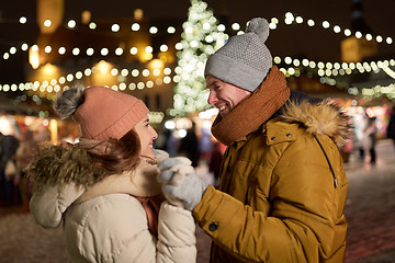 Image showing happy couple holding hands at christmas tree