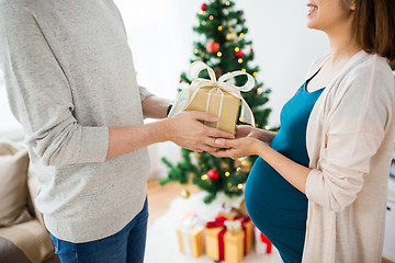 Image showing husband giving christmas present to pregnant wife