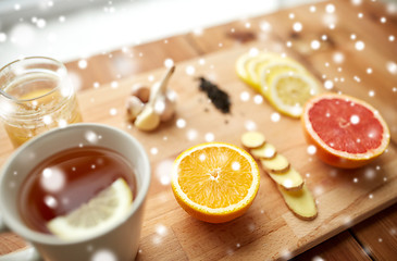 Image showing ginger tea with honey, citrus and garlic on wood