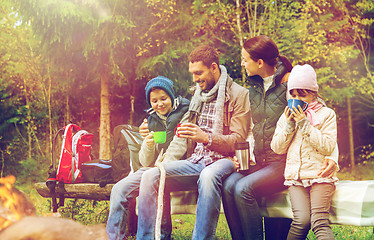 Image showing happy family sitting on bench at camp fire