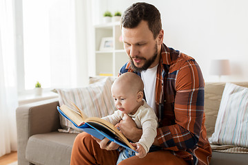 Image showing happy father and little baby boy with book at home