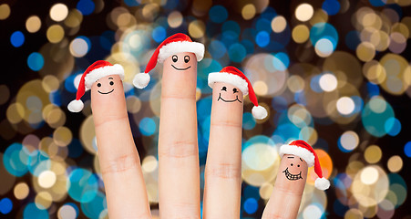 Image showing close up of fingers in santa hats at christmas