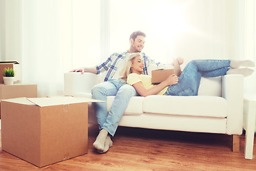 Image showing happy couple with big cardboard boxes at new home