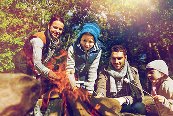 Image showing happy family roasting marshmallow over campfire