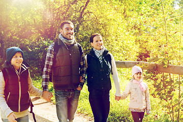 Image showing happy family with backpacks hiking in woods