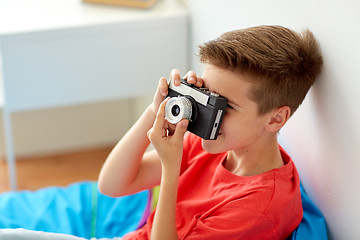 Image showing happy boy with film camera photographing at home