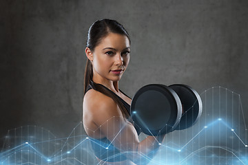 Image showing young woman flexing muscles with dumbbells in gym