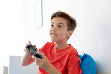 Image showing happy boy with gamepad playing video game at home