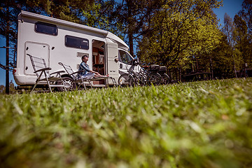 Image showing Woman resting near motorhomes in nature. Family vacation travel,