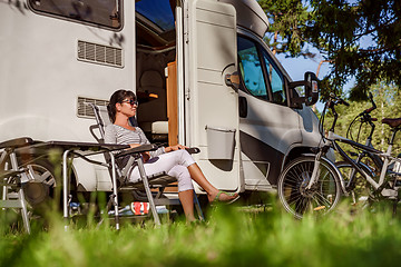 Image showing Woman resting near motorhomes in nature. Family vacation travel,