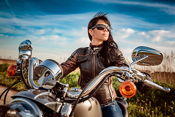 Image showing Biker girl sitting on motorcycle