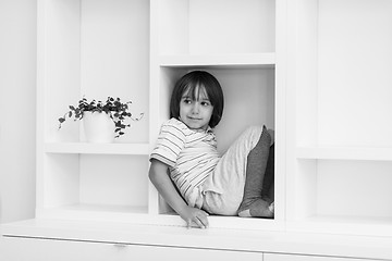 Image showing young boy posing on a shelf