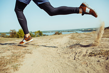 Image showing Running sport. Man runner sprinting outdoor in scenic nature. Fit muscular male athlete training trail running for marathon run.