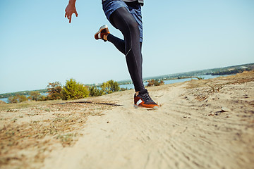 Image showing Running sport. Man runner sprinting outdoor in scenic nature. Fit muscular male athlete training trail running for marathon run.