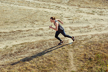 Image showing Running sport. Man runner sprinting outdoor in scenic nature. Fit muscular male athlete training trail running for marathon run.