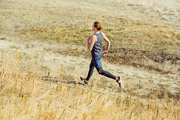 Image showing Running sport. Man runner sprinting outdoor in scenic nature. Fit muscular male athlete training trail running for marathon run.