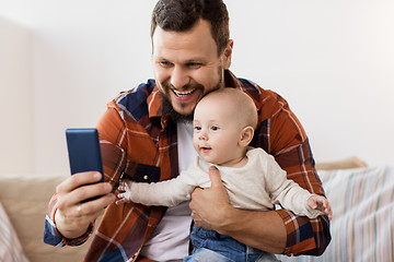 Image showing happy father with baby boy taking selfie at home