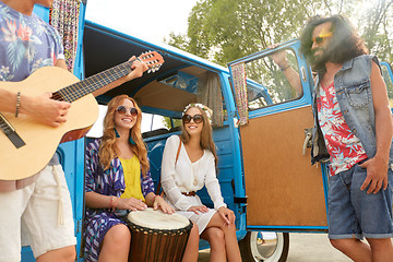 Image showing happy hippie friends playing music in minivan