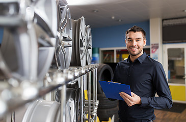 Image showing auto business owner and wheel rims at car service