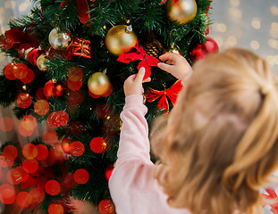 Image showing close up of little girl decorating christmas tree