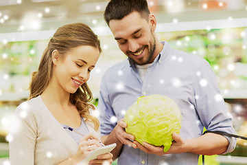 Image showing couple with notebook and cabbage at grocery store