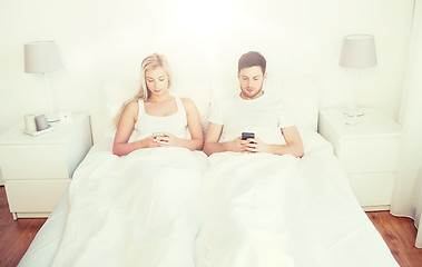 Image showing couple with smartphones in bed