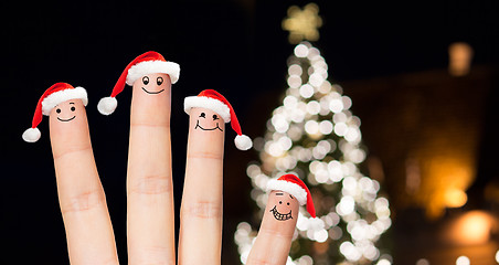 Image showing close up of fingers in santa hats at christmas