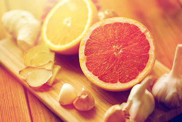 Image showing grapefruit, ginger, garlic and orange on board