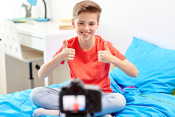 Image showing happy boy with camera recording video at home