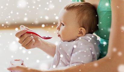 Image showing close up of mother with spoon feeding little baby