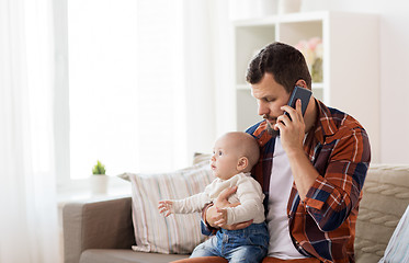 Image showing father with baby calling on smartphone at home