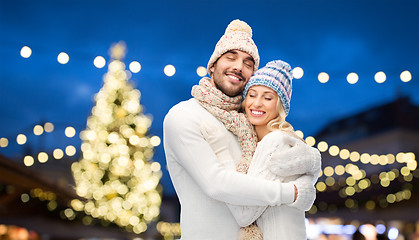 Image showing happy couple hugging over christmas tree lights