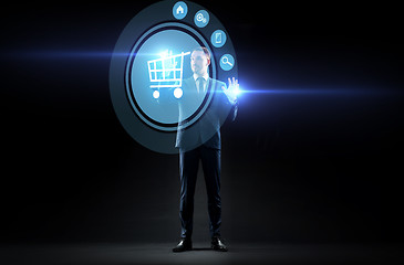 Image showing businessman with shopping cart on virtual screen