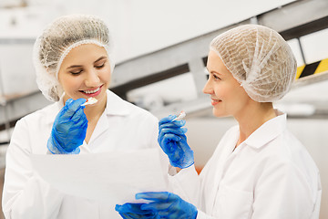 Image showing women technologists tasting ice cream at factory