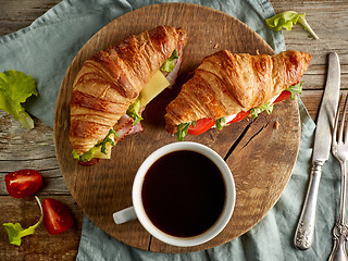 Image showing two croissant sandwiches on wooden table