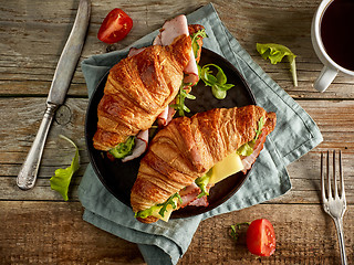 Image showing two croissant sandwiches on wooden table