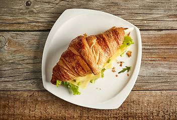 Image showing Croissant sandwich with cheese on wooden table