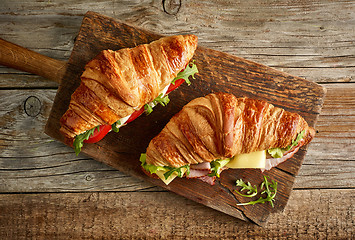 Image showing two croissant sandwiches on wooden table